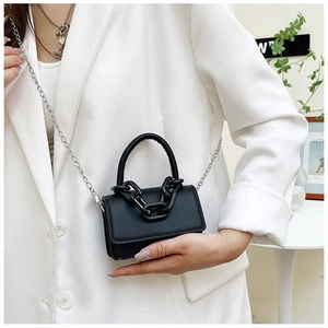 Détail d'un mini sac carré noir avec chaîne épaisse et bandoulière en argent