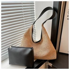 Détail du sac cabas en paille ajouré avec anses en cuir noir et pochette interne