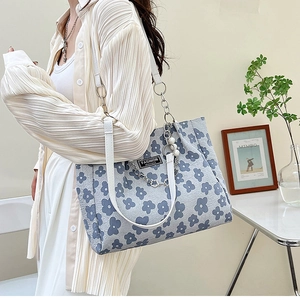 Détail du cabas floral avec bandoulières en cuir blanc, chaînes et perles