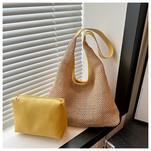 Détail de l'ensemble sac fourre-tout en paille et pochette en cuir jaune pour l'été