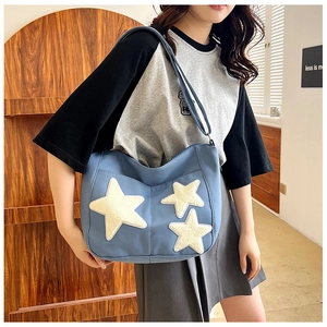 Sac fourre-tout en toile bleue avec écussons étoiles en peluche blanche en scène intérieure