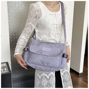 Detail of purple waterproof nylon tote bag featuring a cute bear pattern and side buckle