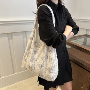 Grand sac cabas blanc texturé avec imprimés papillons gris porté sur l'épaule