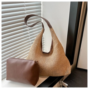 Détail du sac hobo en paille tressée avec pochette intérieure en cuir près d'une fenêtre