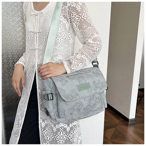 Close-up of printed nylon crossbody bag with bear pattern and adjustable strap details