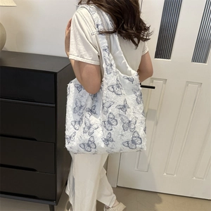 Sac cabas en toile blanche avec imprimé papillon bleu et surface florale texturée