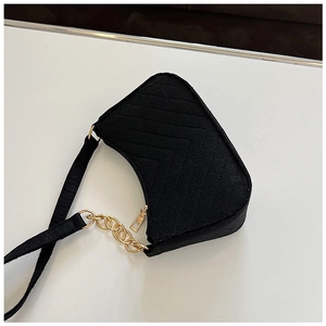 Detail of black felt shoulder bag featuring V-shaped quilting and gold chain strap