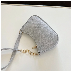 Detail view of grey felt crossbody bag with diamond quilting and gold chain strap