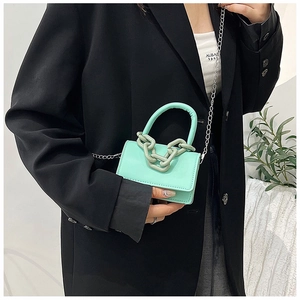 Détail du mini sac carré vert menthe avec chaîne décorative et bandoulière argent