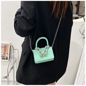Détail du mini sac à rabat vert menthe avec poignée à chaîne épaisse et bandoulière