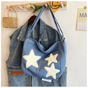 Détail du sac en toile bleue avec écussons étoiles en 3D et fermeture éclair sûre