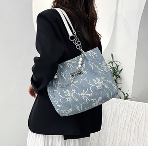 Détail du cabas bleu clair avec breloques perles, chaîne argentée et broderie florale