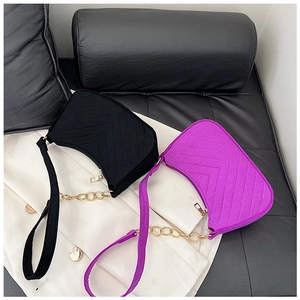 Detail of contrast felt shoulder bags with V-quilted patterns and gold chain straps