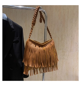 Detail of bohemian brown tassel shoulder bag with braided strap on a silver display hanger