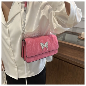Detail of pink pleated crossbody bag with butterfly clasp and silver chain strap