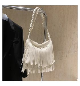 Close-up of a white bohemian tassel shoulder bag featuring a woven strap and fringe detail