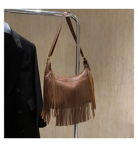 Nahaufnahme einer dunkelbraunen Hobo-Tasche mit Litschi-Struktur, Fransen und breitem Gurt