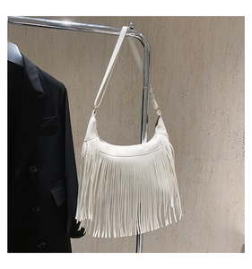 Detail der weißen Hobo-Tasche aus genarbtem Leder mit langen Fransen und Goldbeschlägen