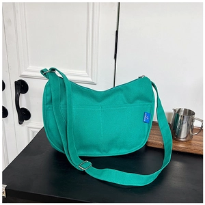 Vue détaillée du sac hobo en toile verte avec poches avant et bandoulière réglable