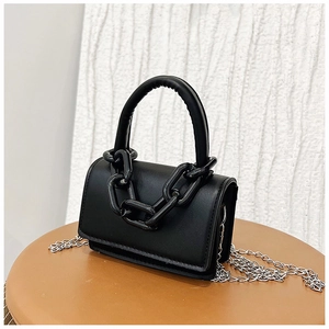 Gros plan du mini sac à main noir mat avec chaîne en résine et bandoulière argentée