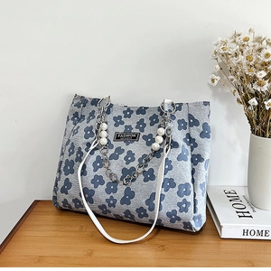 Détail du sac cabas floral avec chaîne argentée, breloques perles et étiquette mode