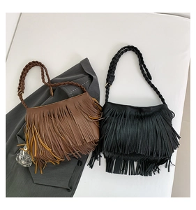 Detail of minimalist tassel shoulder bags in brown and black with braided strap