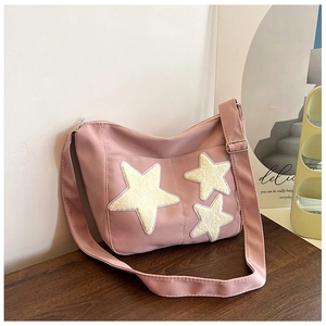 Détail du sac en toile rose avec écussons étoiles en peluche et boucle ajustable