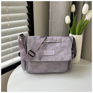 Detail of lavender nylon tote bag featuring gray bear patterns and adjustable strap