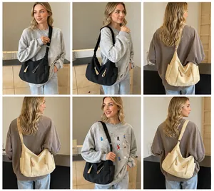 Detailweergave van de grote canvas crossbodytas in zwart en beige voor dames