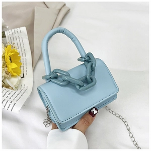 Détail du mini sac carré bleu clair avec chaîne épaisse et bandoulière en métal argenté