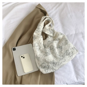 Detail of white tote bag with grey butterfly print and raw edge texture finish