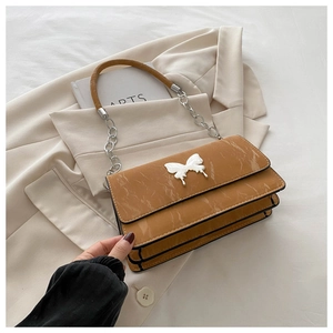 Detailed view of yellow marbled chain bag with a decorative butterfly metal buckle