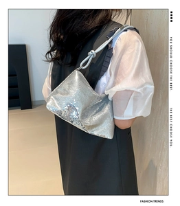 Detail of silver sequin shoulder bag featuring a stylish knotted strap design for women