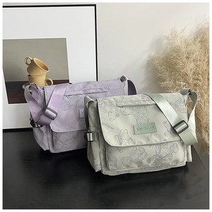 Detail of printed nylon tote bags with teddy bear patterns and front logo patch