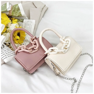 Détail de mini sacs à main roses et beiges avec poignées décoratives à grosse chaîne
