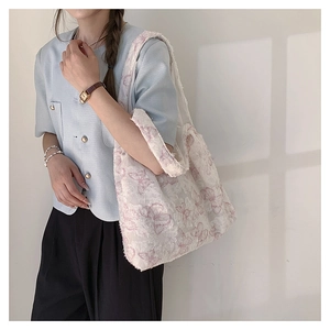 Detailed texture of off-white canvas tote bag featuring pink lace butterfly prints