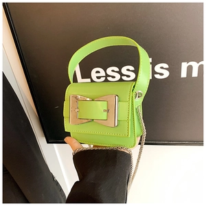 Detail view of neon green mini leather bag with large silver buckle and chain strap