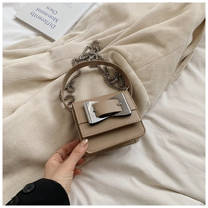 Detail view of khaki mini crossbody bag with silver buckle and metal chain strap