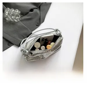Interior view showing the storage capacity for phone and makeup in silver sequin bag
