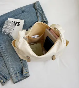Bovenaanzicht van ruime crème canvas tas met notebook en portemonnee aan de binnenkant