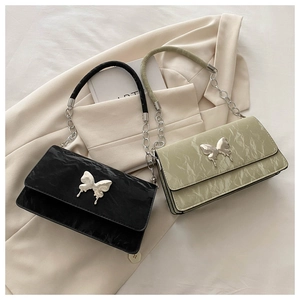 Close-up of metallic butterfly buckle and pleated texture on chic shoulder bags