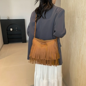 Caramel brown large hobo bag with long fringes and woven shoulder strap for women