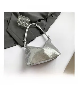 Detailed view of fashionable silver sequin handbag with cylindrical handle for parties