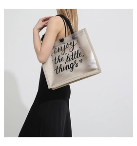 Detail of transparent PVC tote bag with 'enjoy the little things' print and woven trim