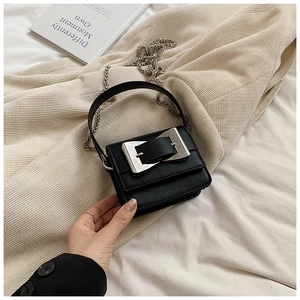 Detail of black leather mini square bag with silver buckle and metal chain strap