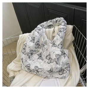 Detail of white tote bag with black butterfly print and fringe texture in a cart