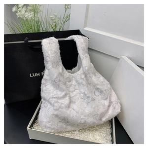 Close-up of white tote bag featuring 3D lace butterfly embroidery and feathered texture