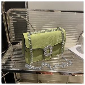 Detail of light green marble texture crossbody bag with silver chain and crystal buckle
