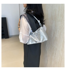 Detail of silver sequin shoulder bag with stylish knotted strap for evening party