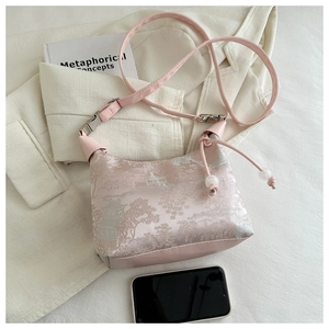 Macro view of pink jacquard bag showing intricate landscape embroidery and bead detail